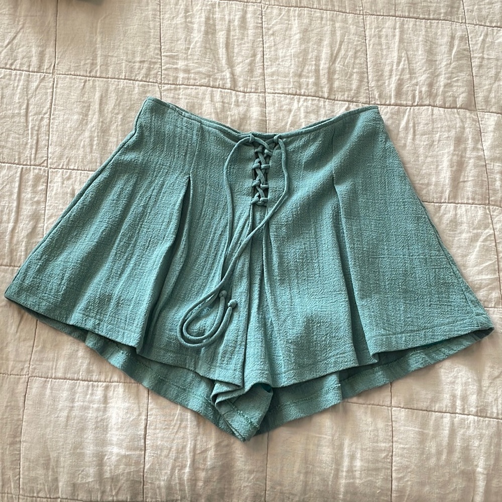High waisted, teal pleated shorts